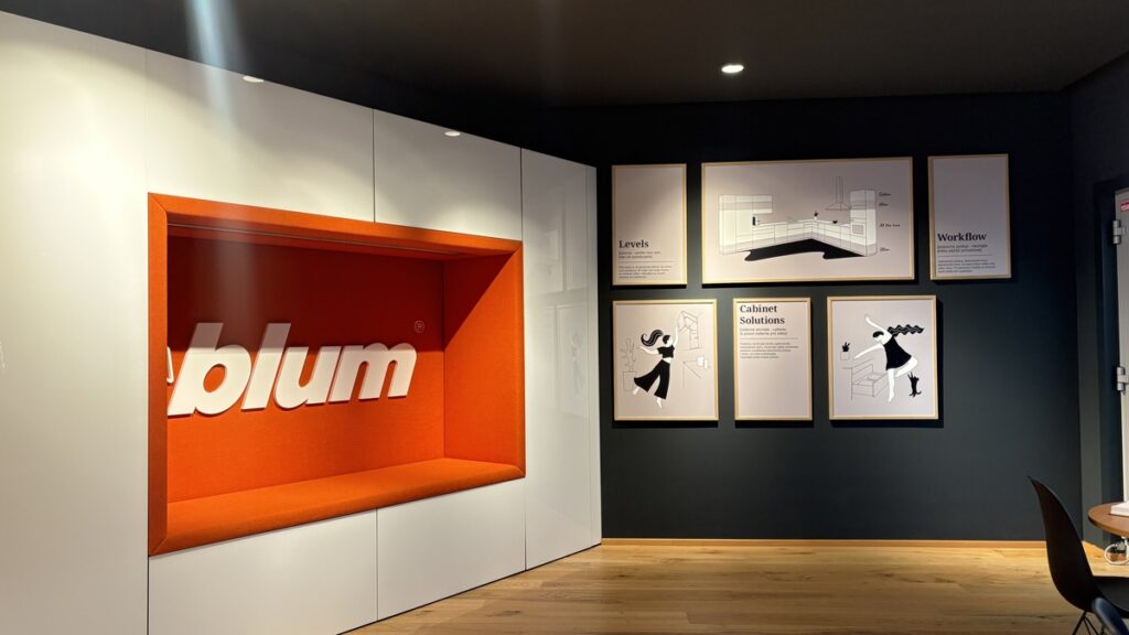 Fotografia so záberom na stenu s logom Blum a obrazy na stene